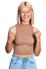 Poster - Beautiful young blonde woman wearing casual style with sleeveless shirt excited for success with arms raised and eyes closed celebrating victory smiling. winner concept.