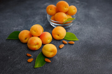 Wall Mural - Delicious ripe Fresh juicy apricots on black background, close-up. Selection of healthy vegetarian food, detox or diet concept.