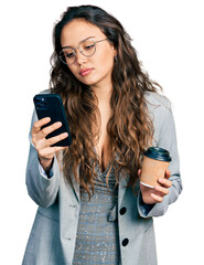 Canvas Print - Young hispanic girl using smartphone and drinking a cup of coffee relaxed with serious expression on face. simple and natural looking at the camera.