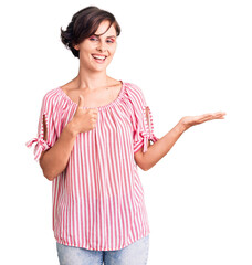 Sticker - Beautiful young woman with short hair wearing casual summer clothes showing palm hand and doing ok gesture with thumbs up, smiling happy and cheerful