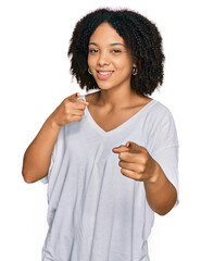 Wall Mural - Young african american girl wearing casual clothes pointing fingers to camera with happy and funny face. good energy and vibes.