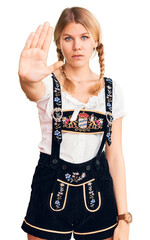 Wall Mural - Young beautiful blonde woman wearing oktoberfest dress doing stop sing with palm of the hand. warning expression with negative and serious gesture on the face.