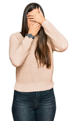 Sticker - Young brunette woman wearing casual winter sweater covering eyes and mouth with hands, surprised and shocked. hiding emotion