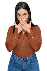 Wall Mural - Young hispanic woman wearing casual clothes shocked covering mouth with hands for mistake. secret concept.