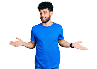 Poster - Young arab man with beard wearing casual blue t shirt smiling showing both hands open palms, presenting and advertising comparison and balance