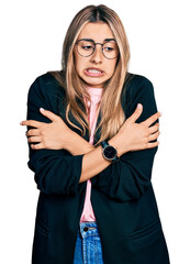 Poster - Hispanic young woman wearing business jacket and glasses shaking and freezing for winter cold with sad and shock expression on face