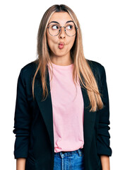 Wall Mural - Hispanic young woman wearing business jacket and glasses making fish face with lips, crazy and comical gesture. funny expression.