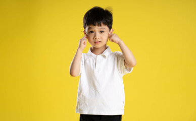 image of asian boy posing on a yellow background.