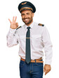 © Krakenimages.com - Handsome man with beard wearing airplane pilot uniform smiling positive doing ok sign with hand and fingers. successful expression.