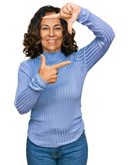 Poster - Middle age hispanic woman wearing casual clothes smiling making frame with hands and fingers with happy face. creativity and photography concept.