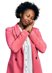 Wall Mural - African american woman with afro hair wearing business jacket sleeping tired dreaming and posing with hands together while smiling with closed eyes.