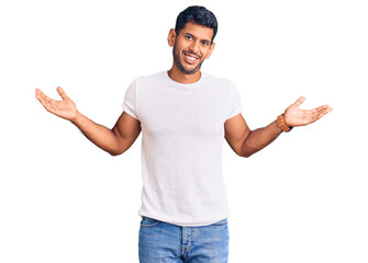 Sticker - Young latin man wearing casual clothes clueless and confused expression with arms and hands raised. doubt concept.