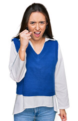 Poster - Young hispanic girl wearing casual clothes angry and mad raising fist frustrated and furious while shouting with anger. rage and aggressive concept.