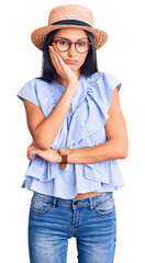 Poster - Young beautiful latin girl wearing summer hat and glasses thinking looking tired and bored with depression problems with crossed arms.