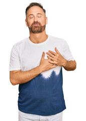 Sticker - Handsome middle age man wearing casual tie dye tshirt smiling with hands on chest with closed eyes and grateful gesture on face. health concept.