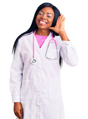 Sticker - Young african american woman wearing doctor stethoscope waiving saying hello happy and smiling, friendly welcome gesture