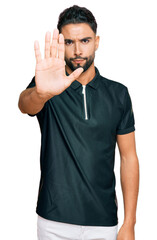 Canvas Print - Young man with beard wearing sportswear doing stop sing with palm of the hand. warning expression with negative and serious gesture on the face.