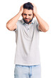 © Krakenimages.com - Young handsome man with beard wearing casual polo suffering from headache desperate and stressed because pain and migraine. hands on head.