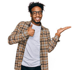Wall Mural - Young african american man with beard wearing casual clothes and glasses showing palm hand and doing ok gesture with thumbs up, smiling happy and cheerful