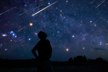 Wall Mural - silhouette of a man enjoying countryside under the starry skies.