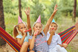 © Inna Vlasova - birthday, childhood and celebration concept - happy kids blowing party horns and having fun in summer outdoors