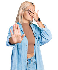 Canvas Print - Beautiful young blonde woman wearing glasses covering eyes with hands and doing stop gesture with sad and fear expression. embarrassed and negative concept.