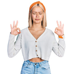 Wall Mural - Beautiful young blonde woman wearing casual white sweater relaxed and smiling with eyes closed doing meditation gesture with fingers. yoga concept.