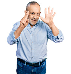 Sticker - Senior man with grey hair and beard wearing casual blue shirt showing and pointing up with fingers number seven while smiling confident and happy.