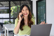 © MIND AND I - Young woman having phone call while online study.