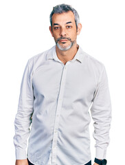 Poster - Middle age hispanic with grey hair wearing casual white shirt looking sleepy and tired, exhausted for fatigue and hangover, lazy eyes in the morning.