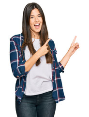 Wall Mural - Young brunette woman wearing casual clothes smiling and looking at the camera pointing with two hands and fingers to the side.