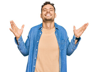 Canvas Print - Young hispanic man wearing casual clothes celebrating mad and crazy for success with arms raised and closed eyes screaming excited. winner concept