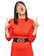 © Krakenimages.com - Young hispanic woman wearing casual clothes amazed and surprised looking up and pointing with fingers and raised arms.