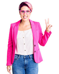 Canvas Print - Young beautiful woman with pink hair wearing business jacket and glasses smiling with happy face winking at the camera doing victory sign. number two.