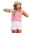 © Krakenimages.com - Young african american woman with braids wearing summer hat doing thumbs up and down, disagreement and agreement expression. crazy conflict