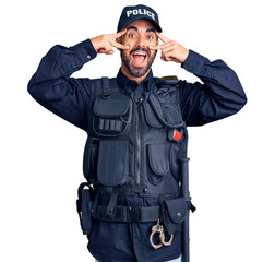 Sticker - Young hispanic man wearing police uniform doing peace symbol with fingers over face, smiling cheerful showing victory