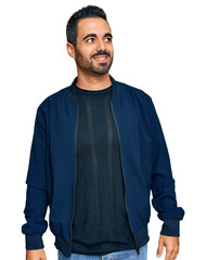 Poster - Young hispanic man wearing casual clothes looking away to side with smile on face, natural expression. laughing confident.