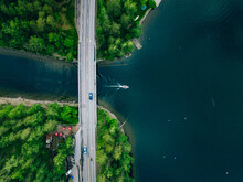 Aerial View Of Bridge Asphalt Road With Car And Blue Water Lake With Boat. Beautiful Summer Landscape In Finland.