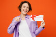 © ViDi Studio - Young happy caucasian woman wear purple shirt white t-shirt casual clothes hold point on gift certificate coupon voucher card for store isolated on plain orange background studio. Lifestyle concept.