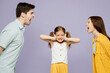 © ViDi Studio - Young sad parent mom dad with child kid girl 6 year old wear blue yellow casual clothes covering ear with hands fingers do not want listen scream isolated on plain purple background Family day concept