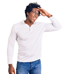 Sticker - Handsome african american man with afro hair wearing casual clothes and glasses very happy and smiling looking far away with hand over head. searching concept.