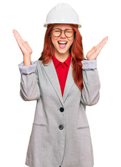 Sticker - Young redhead woman wearing architect hardhat celebrating mad and crazy for success with arms raised and closed eyes screaming excited. winner concept