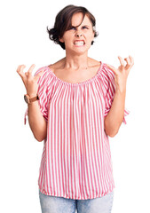 Sticker - Beautiful young woman with short hair wearing casual summer clothes crazy and mad shouting and yelling with aggressive expression and arms raised. frustration concept.