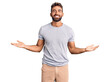 © Krakenimages.com - Young hispanic man wearing casual clothes smiling showing both hands open palms, presenting and advertising comparison and balance