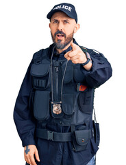 Poster - Young handsome man wearing police uniform pointing displeased and frustrated to the camera, angry and furious with you