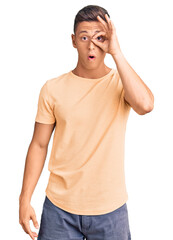 Wall Mural - Young handsome man wearing casual clothes doing ok gesture shocked with surprised face, eye looking through fingers. unbelieving expression.