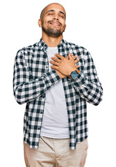 Sticker - Hispanic adult man wearing casual clothes smiling with hands on chest with closed eyes and grateful gesture on face. health concept.