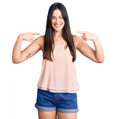 Wall Mural - Young beautiful caucasian woman wearing casual clothes looking confident with smile on face, pointing oneself with fingers proud and happy.