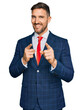 © Krakenimages.com - Handsome man with beard wearing business suit and tie pointing fingers to camera with happy and funny face. good energy and vibes.