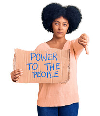 Sticker - Young african american girl holding power to the people banner with angry face, negative sign showing dislike with thumbs down, rejection concept